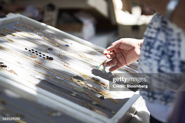 Shopper picks up a necklace displayed by a vendor along South Congress Avenue in Austin, Texas, U.S., on Saturday, July 23, 2016. Consumer confidence...