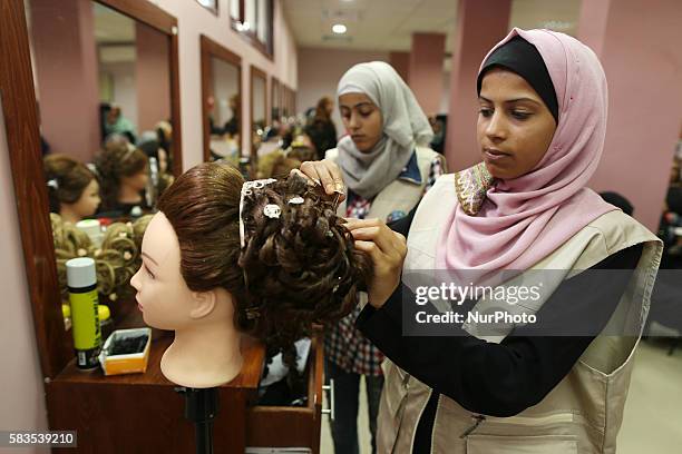 Palestinian girls learn hair dressing during a training session in Gaza City on July 26, 2016.