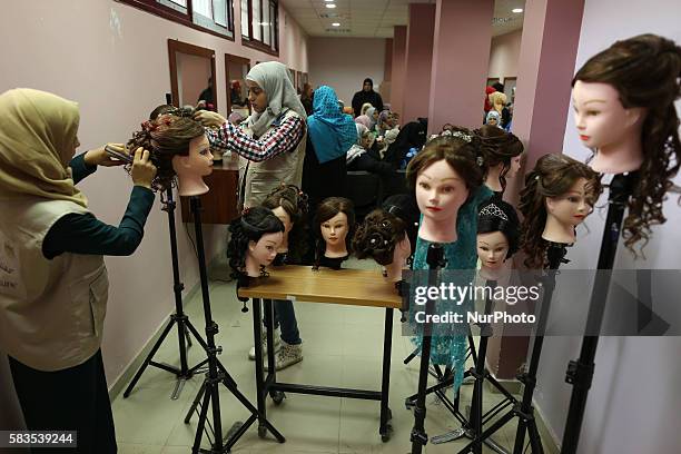 Palestinian girls learn hair dressing during a training session in Gaza City on July 26, 2016.