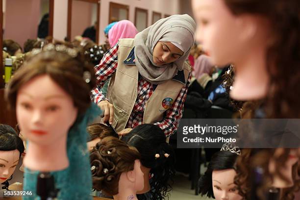 Palestinian girls learn hair dressing during a training session in Gaza City on July 26, 2016.
