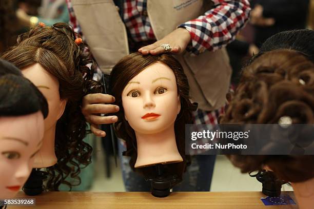 Palestinian girls learn hair dressing during a training session in Gaza City on July 26, 2016.