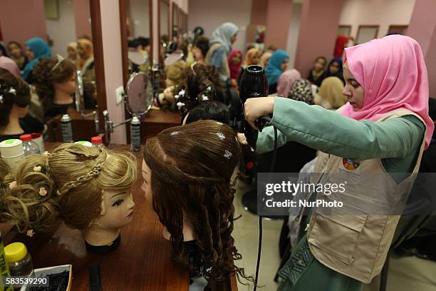 Palestinian girls learn hair dressing during a training session in Gaza City on July 26, 2016.