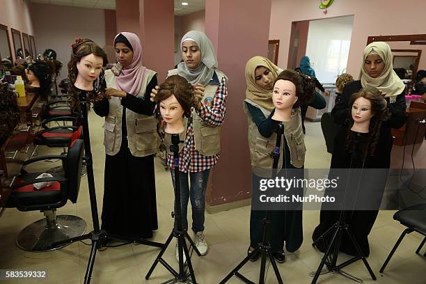 Palestinian girls learn hair dressing during a training session in Gaza City on July 26, 2016.