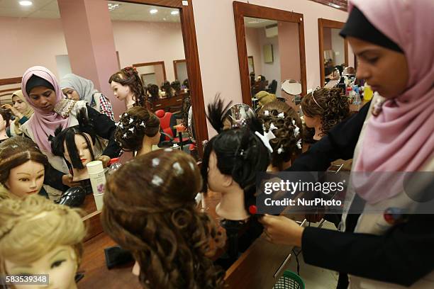 Palestinian girls learn hair dressing during a training session in Gaza City on July 26, 2016.