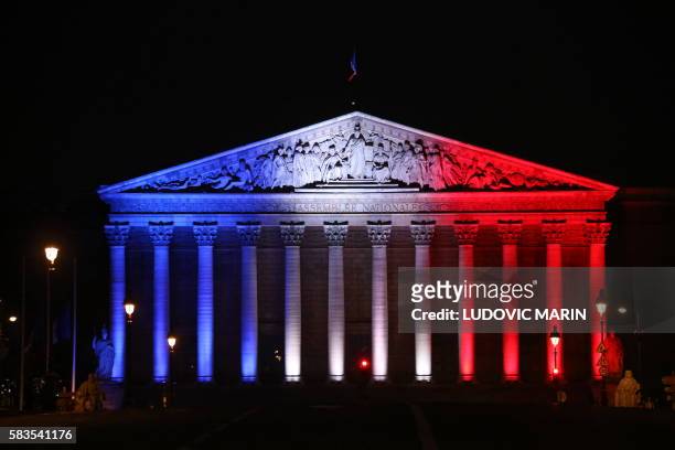 Picture taken on July 26 shows the National Assembly's palais Bourbon in Paris illuminated in the French flag colours in tribute to the victims of...