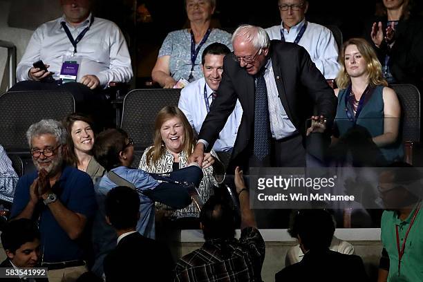 Sen. Bernie Sanders shakes hands with supporters as his wife Jane O'Meara Sanders looks on during the second day of the Democratic National...
