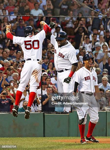 David Ortiz high fives Mookie Betts of the Boston Red Sox after hitting a three-run home run in the third inning during the game against the Detroit...