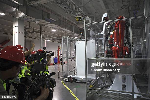 Members of the media film machinery inside the Tesla Motor Inc. Gigafactory in Sparks, Nevada, U.S., on Tuesday, July 26, 2016. Tesla officially...