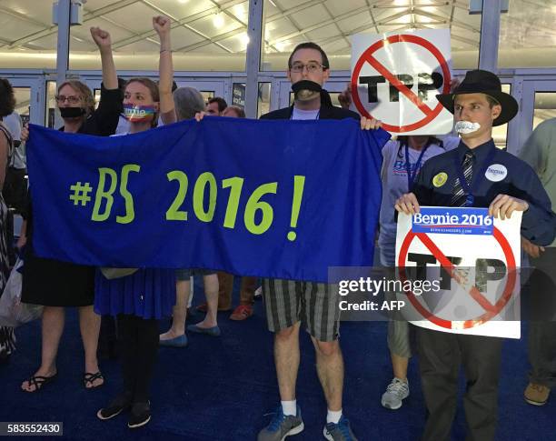 Supporters of Bernie Sanders hold up signs during an improvised protest in front of the media tents on Day 2 of the Democratic National Convention at...