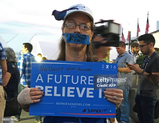 Bernie Sanders supporter hold up a signs during an improvised protest in front of the media tents on Day 2 of the Democratic National Convention at...