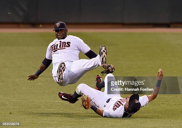 Third baseman Miguel Sano of the Minnesota Twins trips over teammate and right fielder Eddie Rosario after making a catch of the ball hit by Freddie...