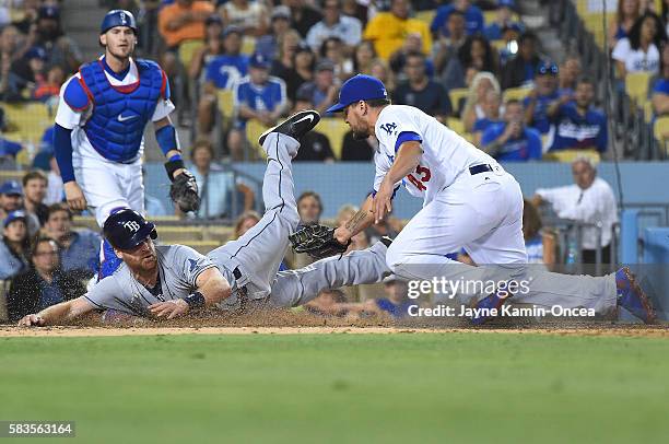 Logan Forsythe of the Tampa Bay Rays scores on a wild pitch and under the tag of Luis Avilan of the Los Angeles Dodgers in the eighth inning of the...