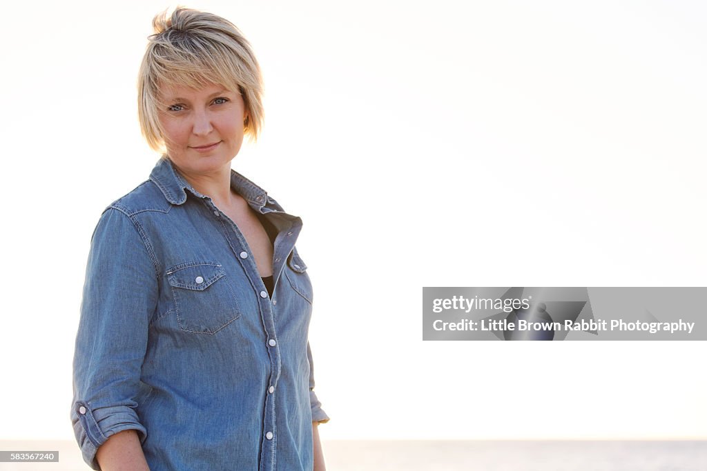 Blonde Woman on a Beach in a Denim Shirt