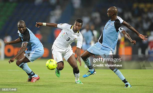 Asamoah Gyan of Ghana and Ndiyapo Letsholathebe and Monpati Thuma of Botswana during the 2012 African Cup of Nations Group D match between Ghana and...