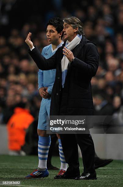 Manchester City coach Roberto Mancini gives instructions to Samir Nasri during the UEFA Europa League round of 16 match between Manchester City and...