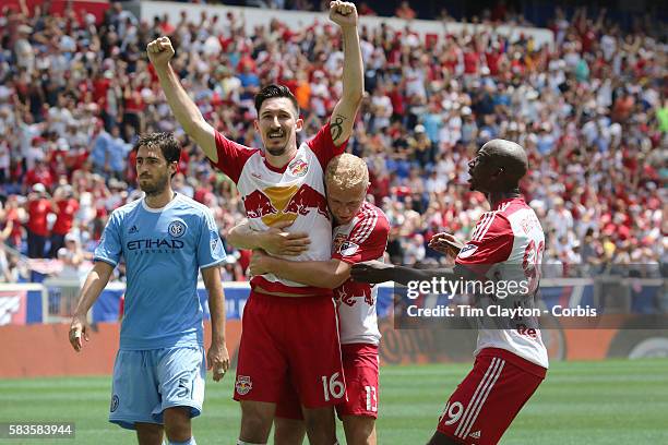 Sacha Kljestan of New York Red Bulls is congratulated by teammates Mike Grella of New York Red Bulls and Bradley Wright-Phillips of New York Red...