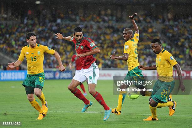 Chahir Belghazouani of Morocco and Dean Furman, Anele Ngcongca and Siyabonga Sangweni of South Africa during the 2013 African Cup of Nations Group A...