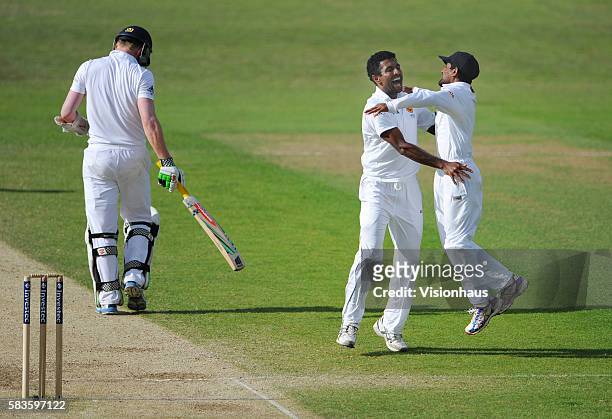 Dhammika Prasad of Sri Lanka celebrates taking the wicket of Sam Robson with Kaushal Silva during Day Four of the 2nd Investec Test between England...