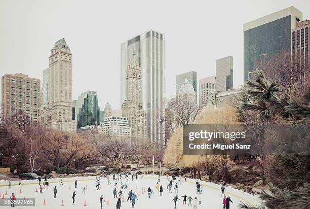 people skating on wollman rink in central park - new york city christmas stock pictures, royalty-free photos & images