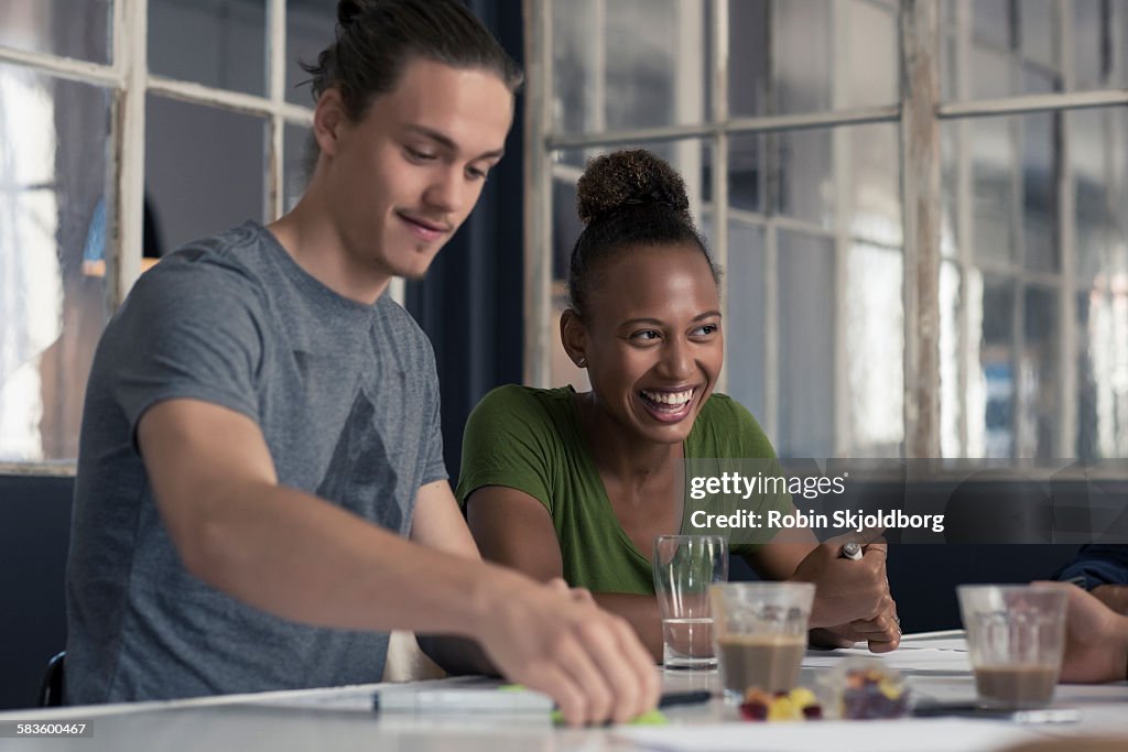 Young Man and Woman sitting at table laughing