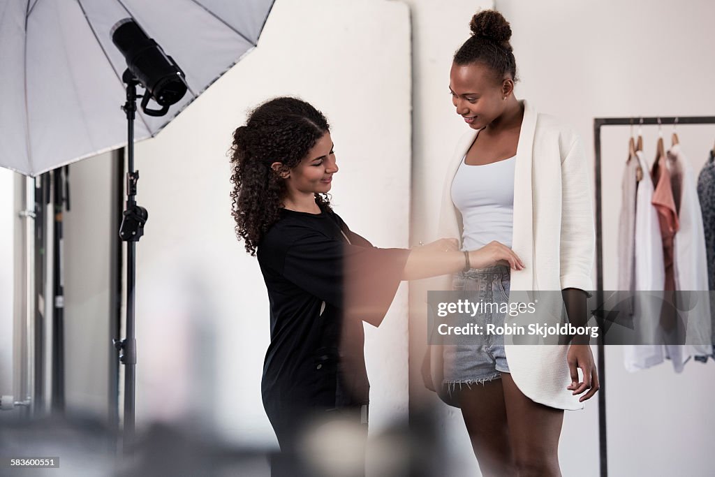 Woman fitting clothes on model in Photo Studio