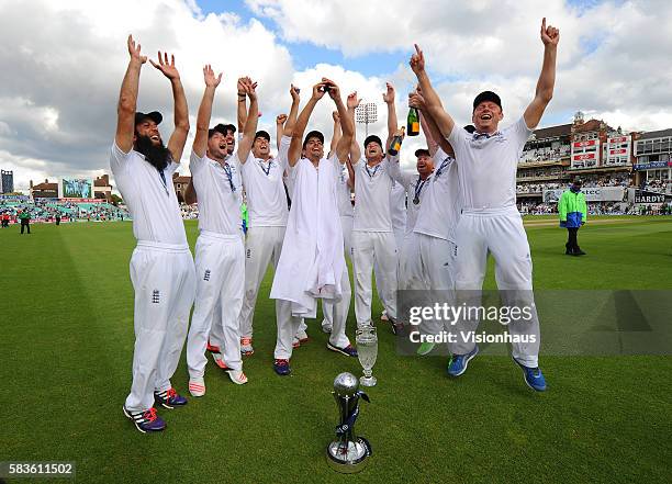 England Captain Alastair Cook raises The Ashes urn surrounded by excited his team mates during the fourth day of the 5th Investec Ashes Test between...