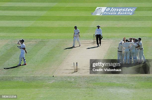 Australia celebrate their win as James Anderson walks from the pitch during the fourth day of the 2nd Investec Ashes Test between England and...