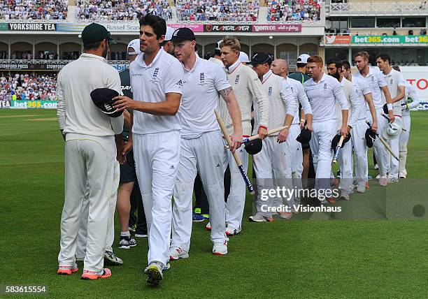 England Captain Alastair Cook leads his team in shaking hands with the Australia players after winning the match and regaining The Ashes during the...