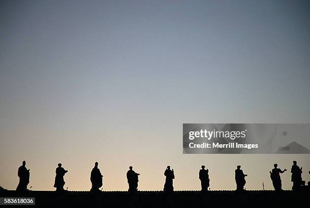 statues of apostle atop st. peter's basilica in vatican city - petersdom stock-fotos und bilder