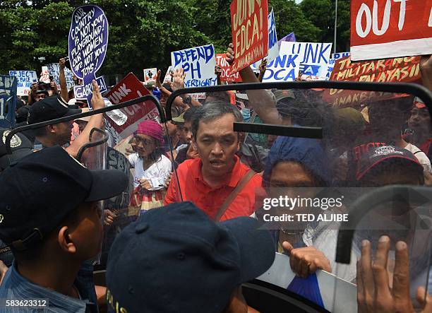 Philippine policemen try to block activists from marching to the US embassy during a protest, to coincide with US Secretary of State John Kerry's...