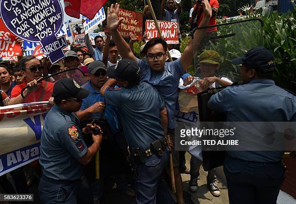 Philippine policemen try to block activists from marching to the US embassy during a protest, to coincide with US Secretary of State John Kerry's...
