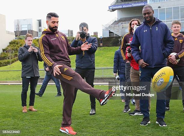 Paul Puopolo of the Hawks instructs Retired Spurs captain Ledley King on how to kick an AFL Football during a Tottenham Hotspur player visit to the...