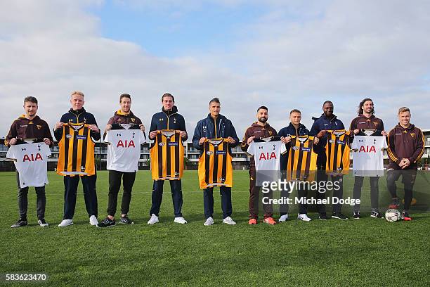 Hawthorn and Tottenham players pose with their guernseys presented to them during a Tottenham Hotspur player visit to the Hawthorn Hawks AFL team at...