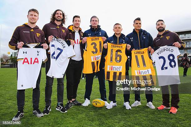 Hawthorn and Tottenham players pose with their guernseys presented to them during a Tottenham Hotspur player visit to the Hawthorn Hawks AFL team at...