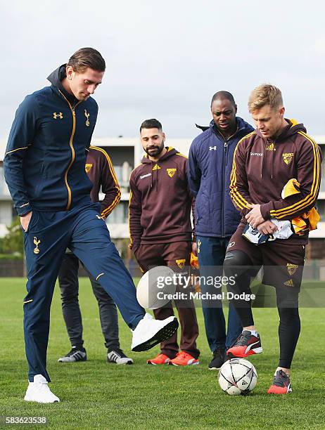 Luke McGee of Tottenham dribbles an AFL Football on his foot next to Sam Mitchell of the Hawks during a Tottenham Hotspur player visit to the...