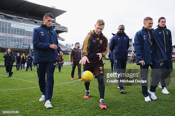 Sam Mitchell of the Hawks instructs Erik Lamela of Tottenham on how to bounce on AFL Football during a Tottenham Hotspur player visit to the Hawthorn...