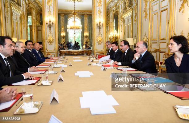 French President Francois Hollande , flanked by French Interior Minister Bernard Cazeneuve and French Prime Minister Manuel Valls , looks on during a...