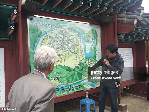 Guide explains to members of the Journalist Forum for World Peace about Andong Hahoe folk village. Photo was taken April 20 at Andong City, South...