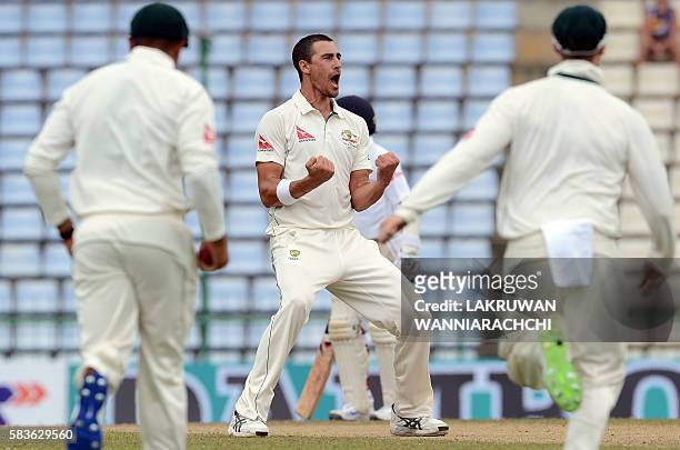 Australia's cricketer Mitchell Starc celebrates with teammates after he dismissed Sri Lanka's cricketer Kusal Perera during the second day of the...