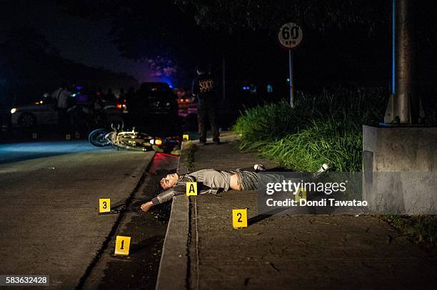 Police examine a crime scene where an alleged drug dealer was killed in an alleged shootout with police on July 22, 2016 in Manila, Philippines....