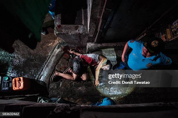 Police examine the body of an alleged drug dealer killed in a shooutout with swat teams during a drug raid on July 21, 2016 in Manila, Philippines....