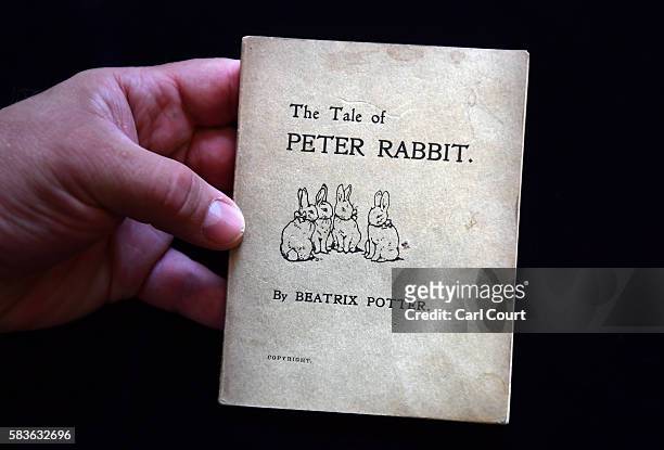 An assistant holds a first edition of The Tale of Peter Rabbit by Beatrix Potter at Dreweatts and Bloomsbury Auctions on July 27, 2016 in London,...