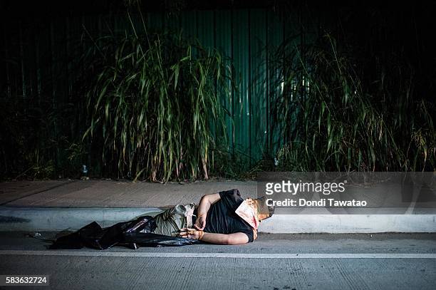 An alleged drug dealer and victim of a summary execution with hands bound and his head wrapped in tape lie on a road on July 27, 2016 in Manila,...