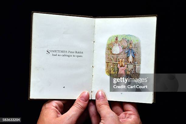 An assistant holds a first edition of The Flopsy Bunnies by Beatrix Potter at Dreweatts and Bloomsbury Auctions on July 27, 2016 in London, England....