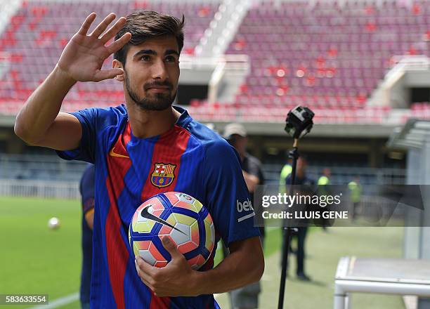 New Barcelona's Portuguesse forward Andre Gomes waves as he arrives on fiels for his official presentation at the Camp Nou stadium in Barcelona on...