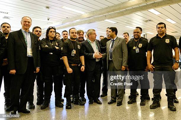 President of the International Olympic Committee Thomas Bach poses with Brazilian federal police officers on his arrival for Rio 2016 Olympic games...