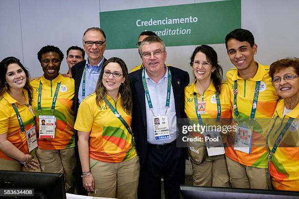 President of the International Olympic Committee Thomas Bach poses with volunteers after receiving his credential card on his arrival for Rio 2016...