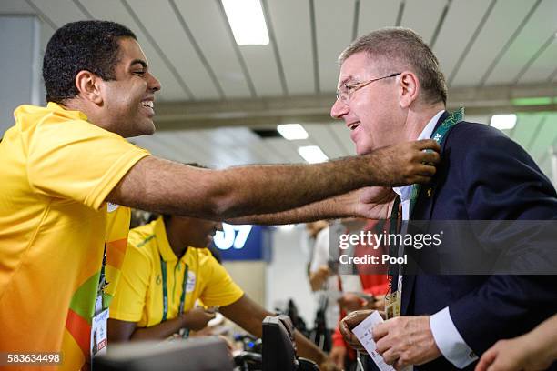 President of the International Olympic Committee Tomas Bach asks a volunteer for his credential card on his arrival for Rio 2016 Olympic Games at...