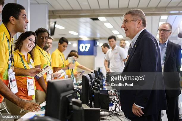 President of the International Olympic Committee Tomas Bach asks a volunteer for his credential card on his arrival for Rio 2016 Olympic Games at...