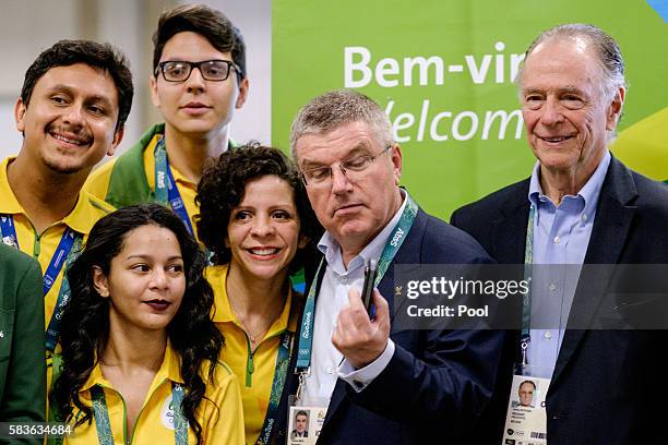 President of the International Olympic Committee Tomas Bach looks at a 360-degree camera given by an official videographer as Carlos Nuzman ,...